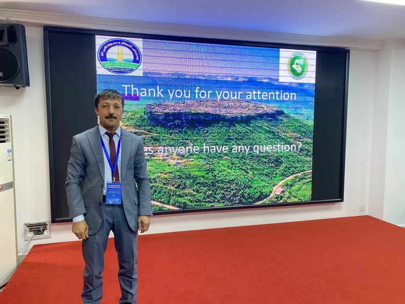 A man standing in front of a presentation on a screen.