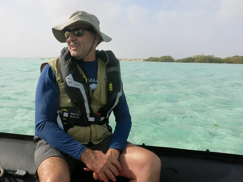 A marine ecologist sitting on a boat during an expedition.