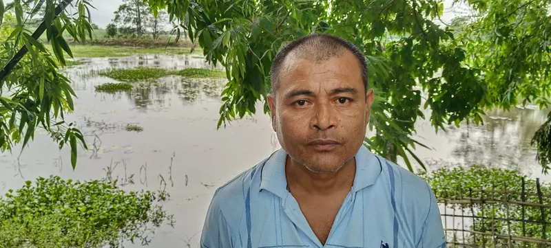 A man standing in front of a pond