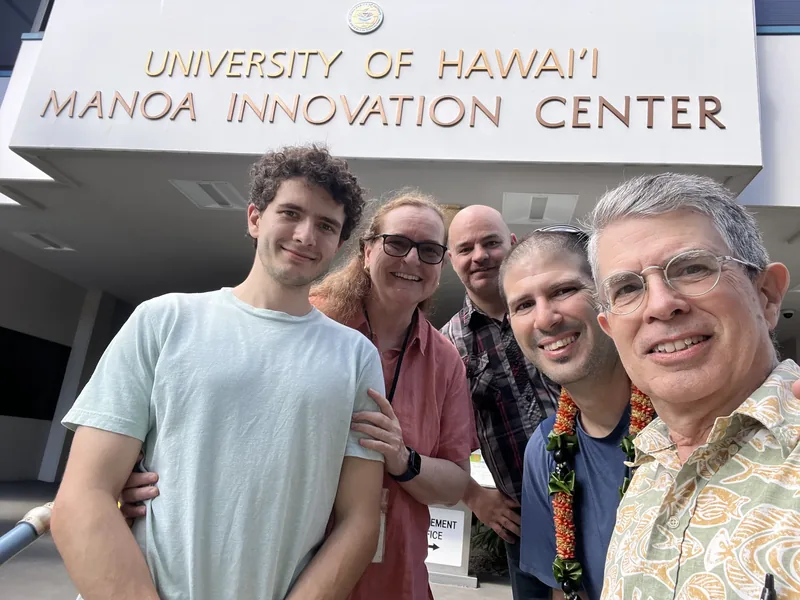 A group of people outside a university entrance.