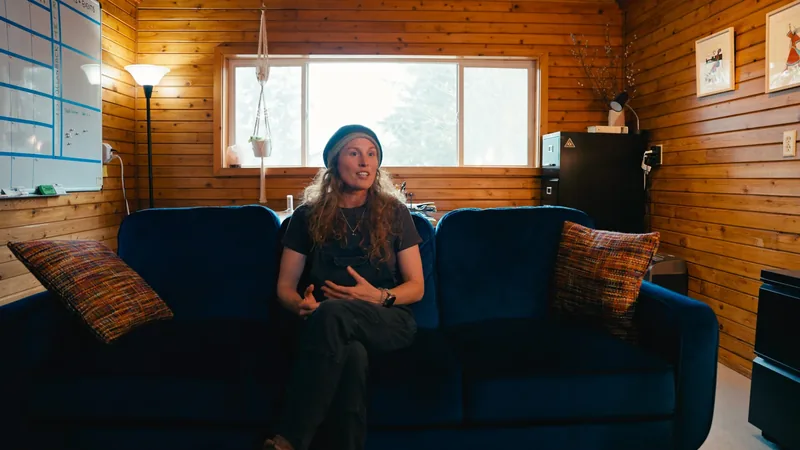 A woman sitting on a sofa in a wood-panelled office