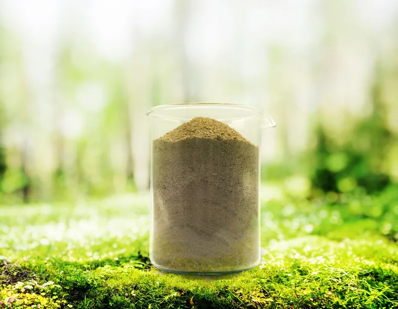 A beaker filled with grey powder.