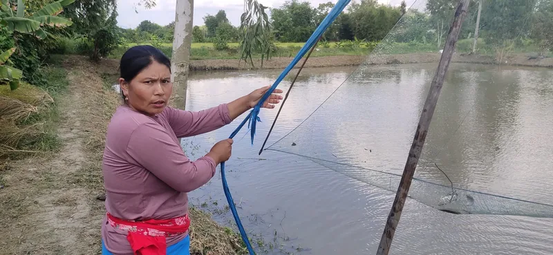 a woman pulling in a net